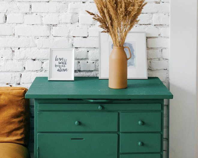 Green drawers with a vase on top.